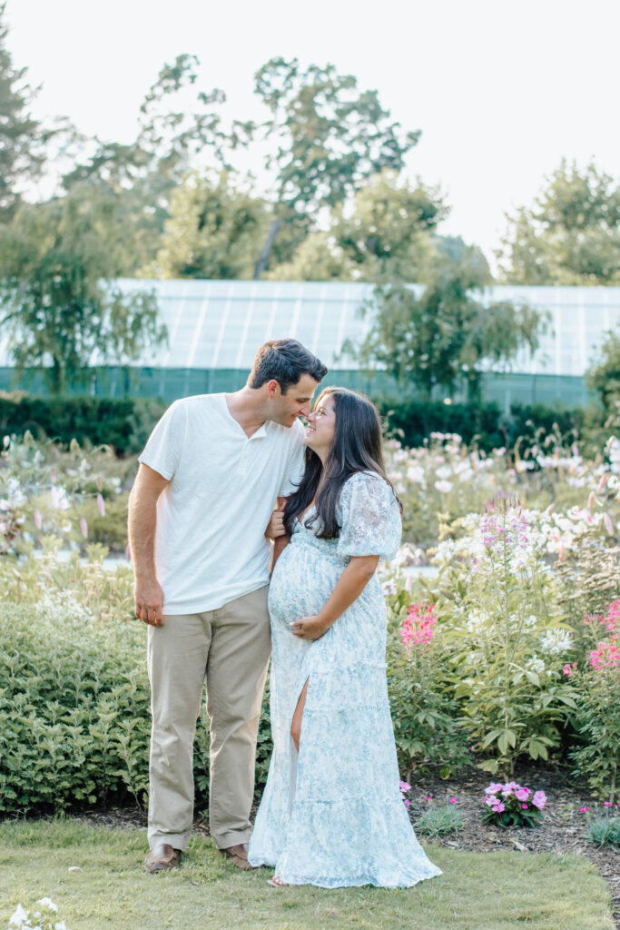 garden maternity session, mom holding belly looking at each other